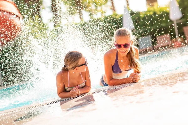 Feliz hermosas chicas divirtiéndose en la piscina — Foto de Stock