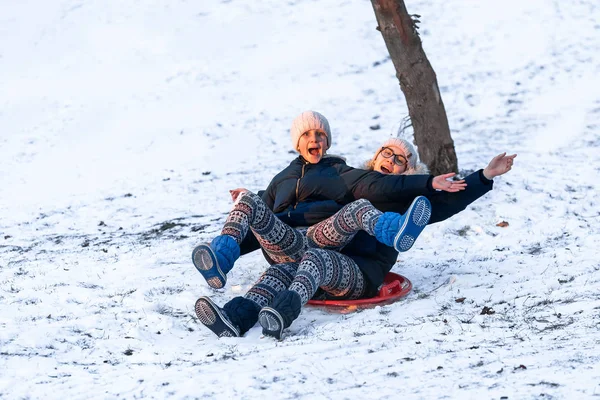 Meninas deslizando da colina no inverno — Fotografia de Stock