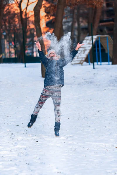 Menina adolescente feliz jogando bolas de neve e pulando — Fotografia de Stock