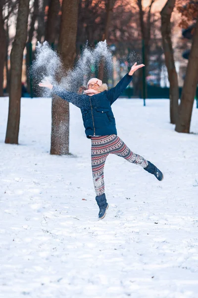 Menina adolescente feliz jogando bolas de neve e pulando — Fotografia de Stock