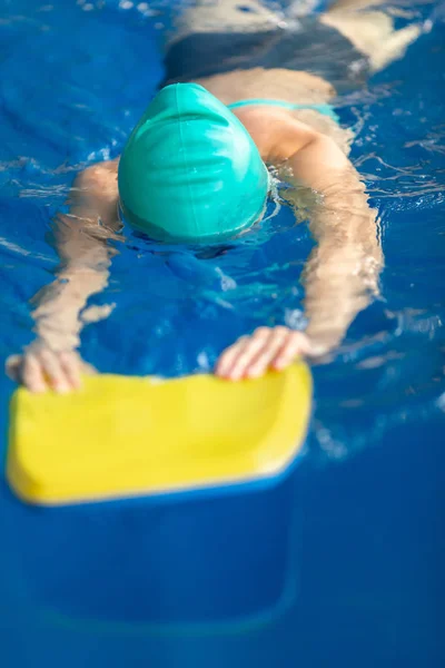 Schattig klein meisje training in een zwembad — Stockfoto