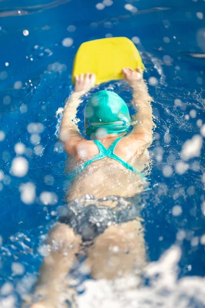 Милая маленькая девочка тренируется в бассейне — стоковое фото