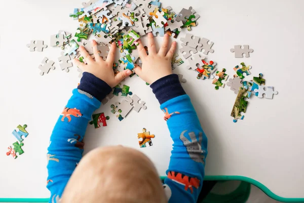 Дитячий хлопчик вирішує головоломку на столі — стокове фото