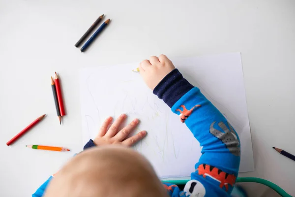 Малыш рисует картинку цветными карандашами — стоковое фото