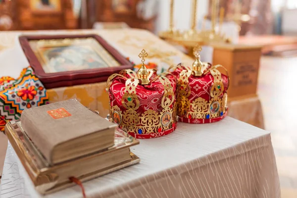 Orthodox wedding crowns, church icons, church books, gospel on the table