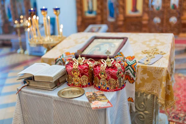 Orthodox wedding crowns, church icons, church books, gospel on the table