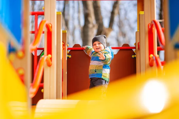 幸せな小さな赤ちゃんが遊び場の屋外で遊んでいる — ストック写真