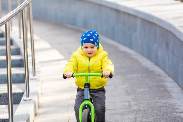 快乐的小男孩在公园外面骑着跑车 — 图库照片