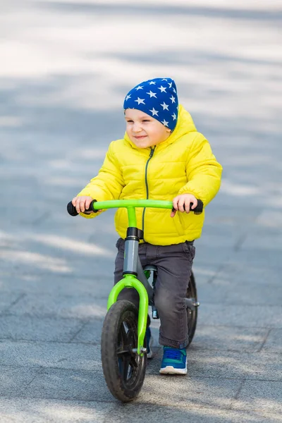 公園の屋外でランバイクに乗って幸せな男の子 — ストック写真