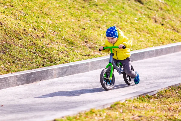 公園の屋外でランバイクに乗って幸せな男の子 — ストック写真