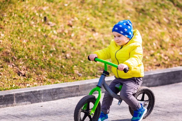 公園の屋外でランバイクに乗って幸せな男の子 — ストック写真