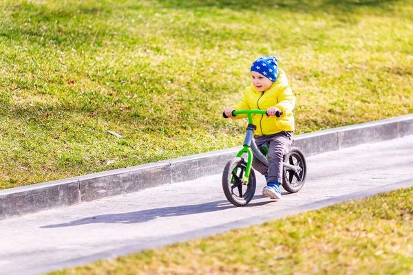 公園の屋外でランバイクに乗って幸せな男の子 — ストック写真