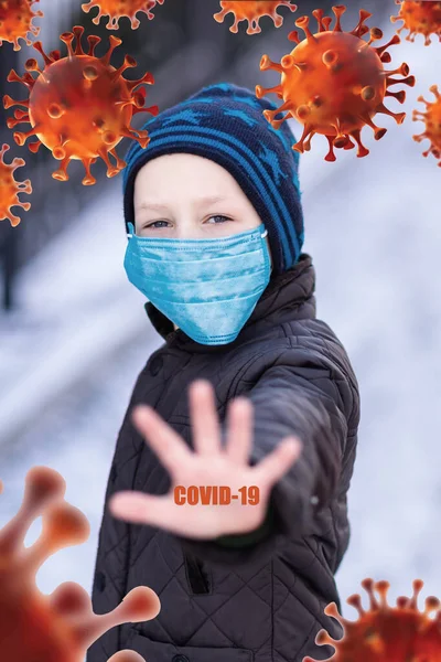 Young little boy wearing medical face masks to protect himself from pollution, germs and coronavirus on the street during quarantine. Showing stop hand gesture for stop corona virus outbreak. Corona virus, covid -19, pandemic protection concept.
