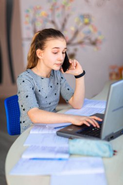 Evinde dizüstü bilgisayarı ve sanal bir sınıfta ders çalışan güzel bir kız öğrenci. Karantina sırasında uzaktan eğitim ve öğrenme, e-öğrenme, çevrimiçi öğrenme kavramı