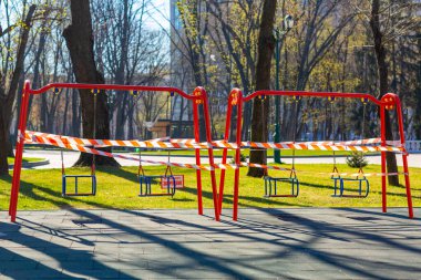 Çocuk parkı kapalı ve küresel koronavirüs karantinası için uyarı bandıyla sarılmış. Çocuk parkında yok. Koronavirüsün önlenmesi COVID-19.