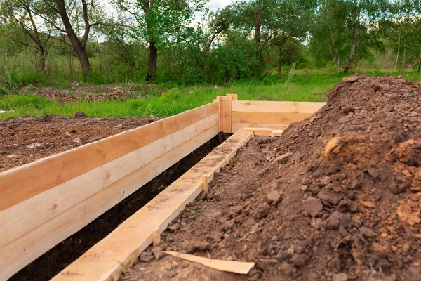 Wooden formwork for creating strip foundation for new house basis. Constructing house from the beginning concept — Stock Image Wooden Formwork Creating Strip Foundation New House Basis Constructing House Royalty Free Stock Images