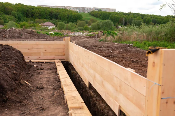 Wooden formwork for creating strip foundation for new house basis. Constructing house from the beginning concept — Stock Image Wooden Formwork Creating Strip Foundation New House Basis Constructing House Stock Photo