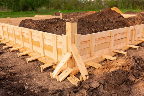 Wooden formwork for creating strip foundation for new house basis. Constructing house from the beginning concept — Stock Image Wooden Formwork Creating Strip Foundation New House Basis Constructing House Royalty Free Stock Images