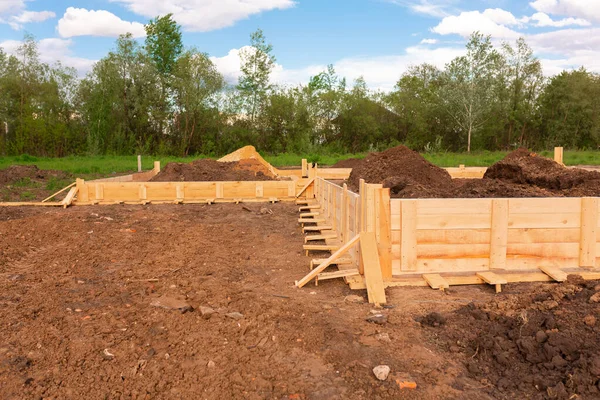 Wooden formwork for creating strip foundation for new house basis. Constructing house from the beginning concept — Stock Image Wooden Formwork Creating Strip Foundation New House Basis Constructing House Royalty Free Stock Photos
