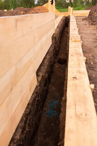 Wooden formwork for creating strip foundation for new house basis. Constructing house from the beginning concept — Stock Image Wooden Formwork Creating Strip Foundation New House Basis Constructing House Stock Photo