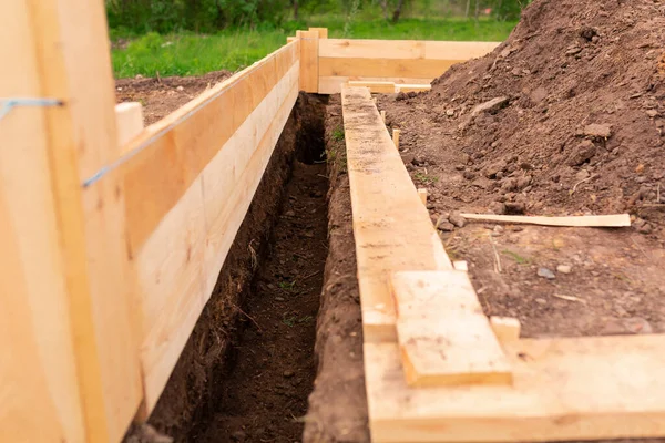 Wooden formwork for creating strip foundation for new house basis. Constructing house from the beginning concept — Stock Image Wooden Formwork Creating Strip Foundation New House Basis Constructing House Stock Picture