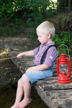 ahşap köprü üzerinde oturan çocuk