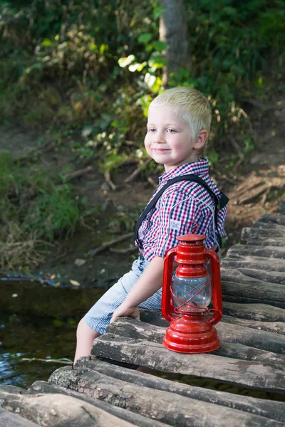 Chlapce, který seděl na dřevěný most — Stock fotografie