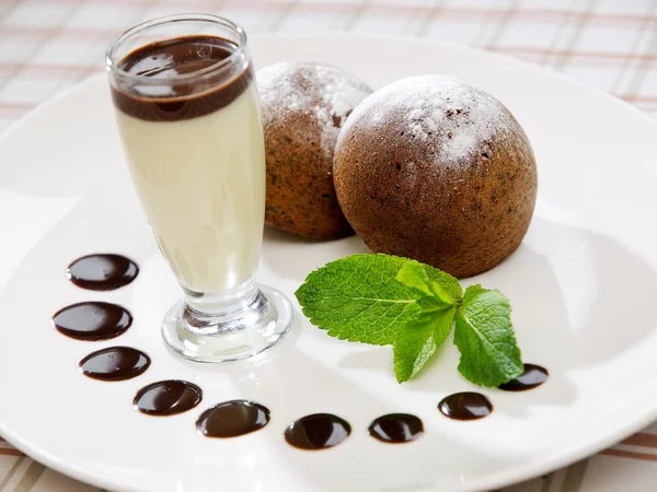 Two freshly baked brownie-type sponge cake with vanilla sauce — Stock Photo, Image