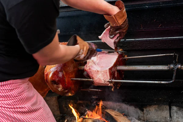 Market, street food, food festival. Cooking a big piece of pork on open fire. East European traditions. Food concept.
