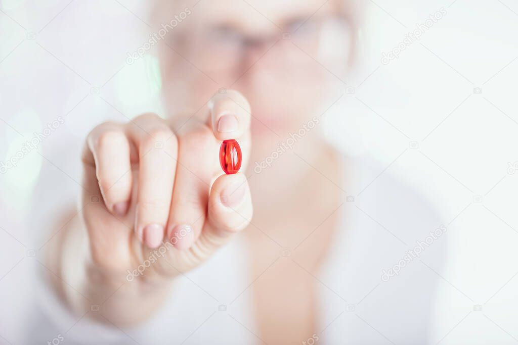 Pink pill in hand on white background. Close up photo. Medicine concept