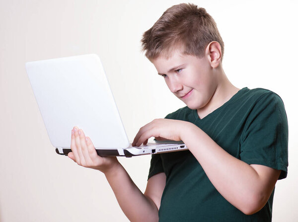 excited 10 - 12 years old boy (teenager) use his laptop