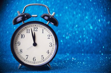 Mavi parıltılı arka planda çalar saat. Bokeh noel ağacı şeklinde.