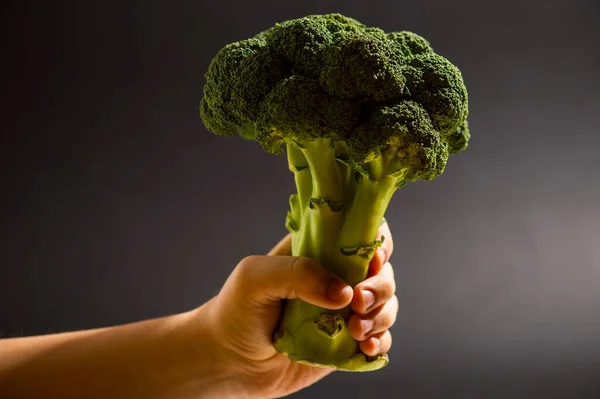 Mänsklig Hand Håller Färsk Grön Broccoli Svart Bakgrund — Stockfoto