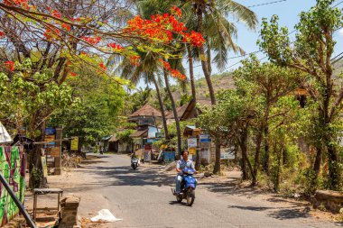 BALI, INDONESIA - 01 Aralık 2019: Geleneksel Bali Kabile Köyü. Arabalar ve motosikletler Amed, Bali, Endonezya 'da cadde boyunca sürüyorlar