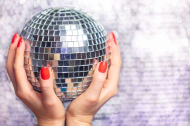 Disko topu ile güzel kadın ellerinde kapatın. Kırmızı manikür