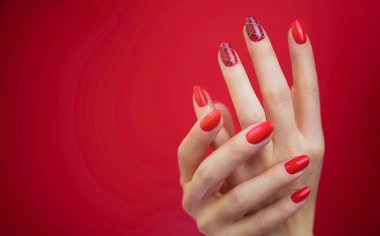  Kırmızı arka plan güzel bakımlı kadının ellerinde.