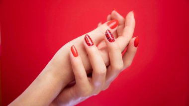  Kırmızı arka plan güzel bakımlı kadının ellerinde.