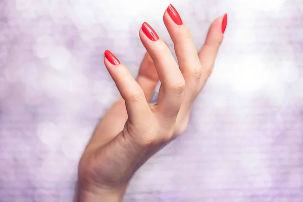 Close-up op mooie vrouwelijke handen met rode manicure. — Stockfoto