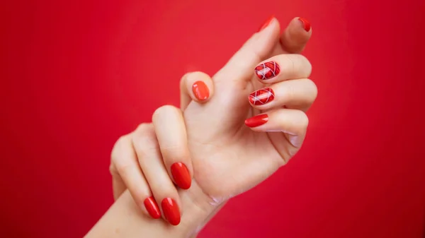 Hermosas manos de mujer cuidadas sobre fondo rojo . — Foto de Stock