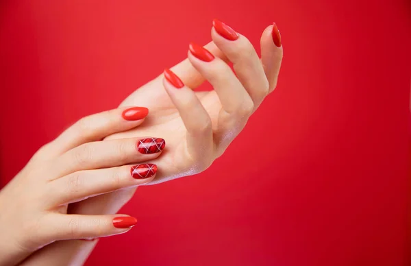 Belas mãos de mulher cuidada no fundo vermelho . — Fotografia de Stock