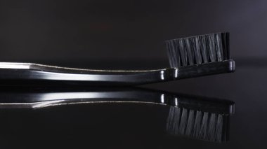 İzole koyu arka plan üzerinde siyah diş fırçası