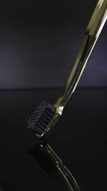 Koyu arkaplanda izole edilmiş Altın Diş fırçası..