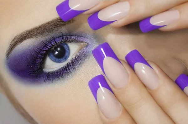 Portret van een jonge vrouw met grote blauwe ogen en prefect manicure close-up. — Stockfoto