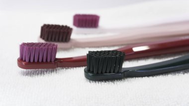 Renkli diş fırçaları beyaz arkaplanda izole edilmiş olarak yakın plan.