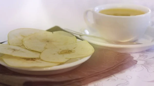 Чашка чая с запечёнными яблочными чипсами — стоковое фото