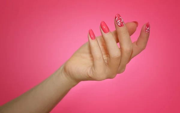 Manicured woman's nails with pink nailart with flowers. — Stock Photo, Image