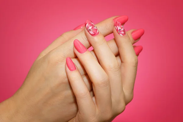 Unhas da mulher cuidada com nailart rosa com flores . — Fotografia de Stock