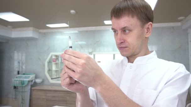 Kosmetolog plocka upp läkemedel i en spruta och förbereder den för injektion. — Stockvideo
