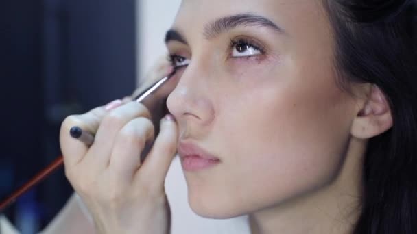 Maquillaje artista aplicar maquillaje a un atractivo jóvenes mujeres . — Vídeo de stock