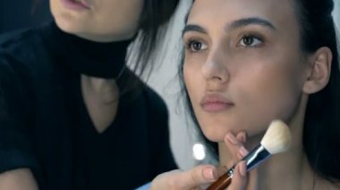 Makyaj sanatçısı için çekici bir genç kadın makyaj uygulamak. 